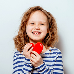 niña sosteniendo un corazón con una gran sonrisa