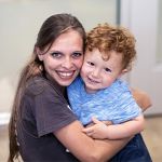 maestra y niño de dos años abrazándose en la guardería