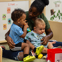 Teacher with two toddlers on her lap