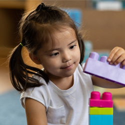 little girl looking at legos