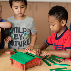 niños jugando con troncos, construyendo cabaña