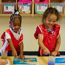 two girls doing a craft in preschool class