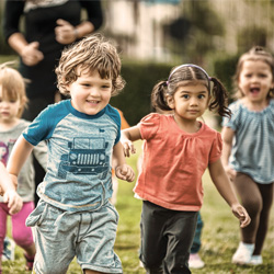 Four kids running in field