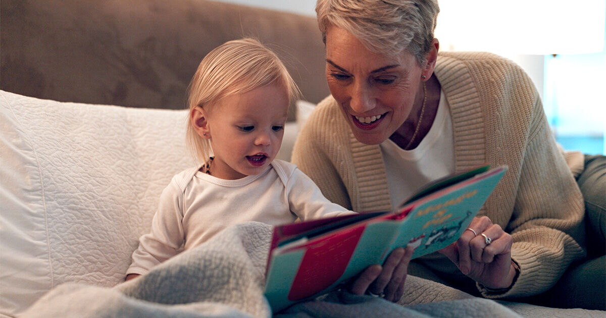 Bedtime Routine Header-2 A parent and young child sharing a bedtime story while sitting together on a bed.