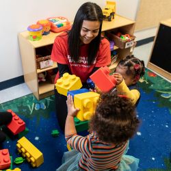 teacher and children playing with large legos