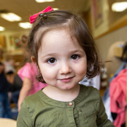 niña sonriendo con camisa verde