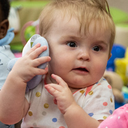 niña sosteniendo un juguete como un teléfono