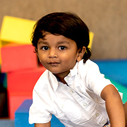little boy playing with wooden truck blocks in the back