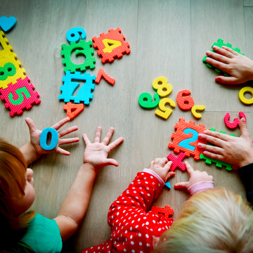 two kids playing with foam numbers
